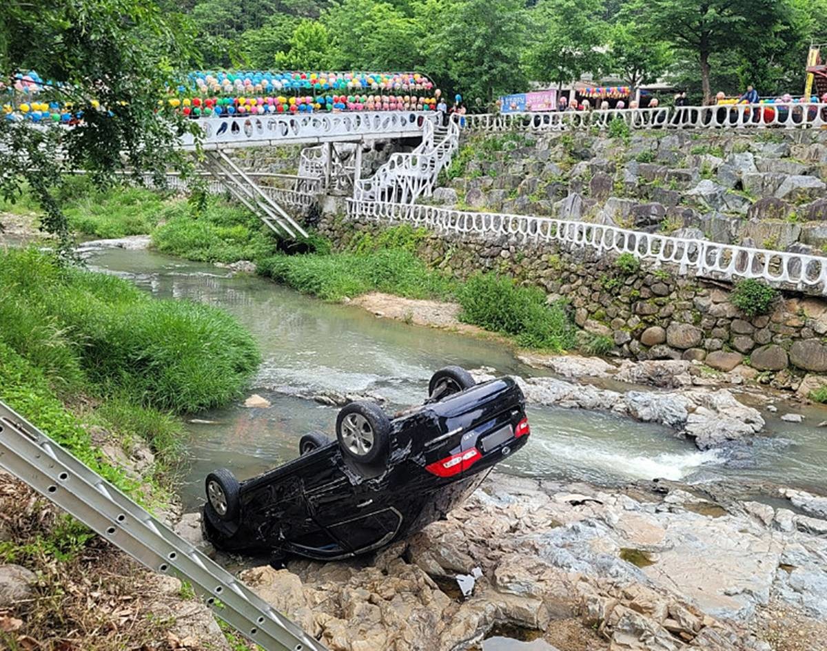 사진은 부처님오신날 용운사 차량 추락 사고 모습...부처님오신날인 24일 경북 칠곡군 가산면 용운사 주차장에서 70~80대 부부가 탄 승용차가 후진하던 중 약 2m 아래 계곡으로 추락했다. 두 사람은 경미한 부상을 입고 병원으로 이송됐으며, 경찰은 페달 조작 미숙 가능성을 조사 중이다 / 칠곡경찰서 제공, 연합뉴스