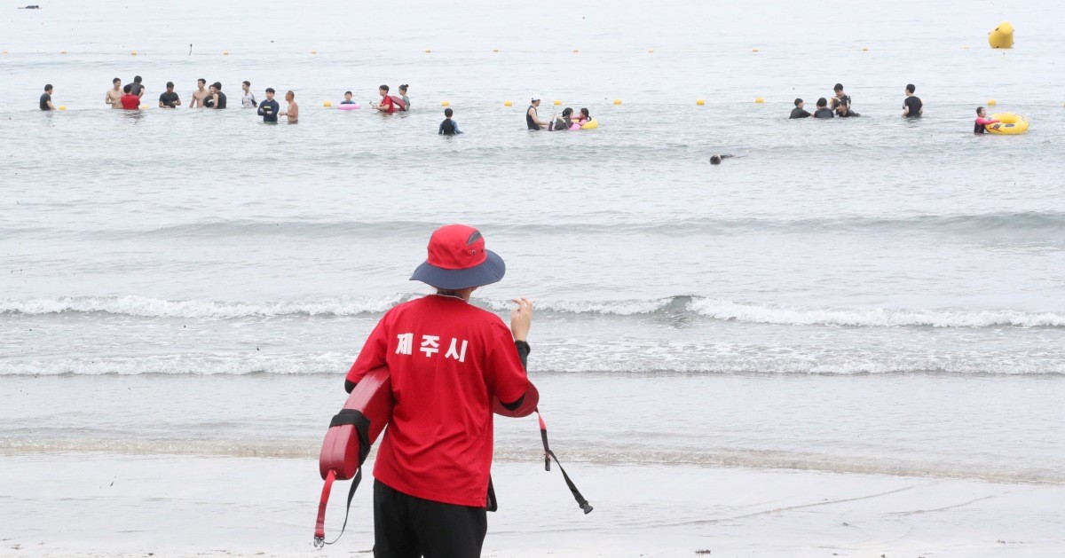 제주시 삼양해수욕장에서 제주시 안전요원이 물놀이를 하는 도민과 관광객들을 바라보고 있다. / 뉴스1