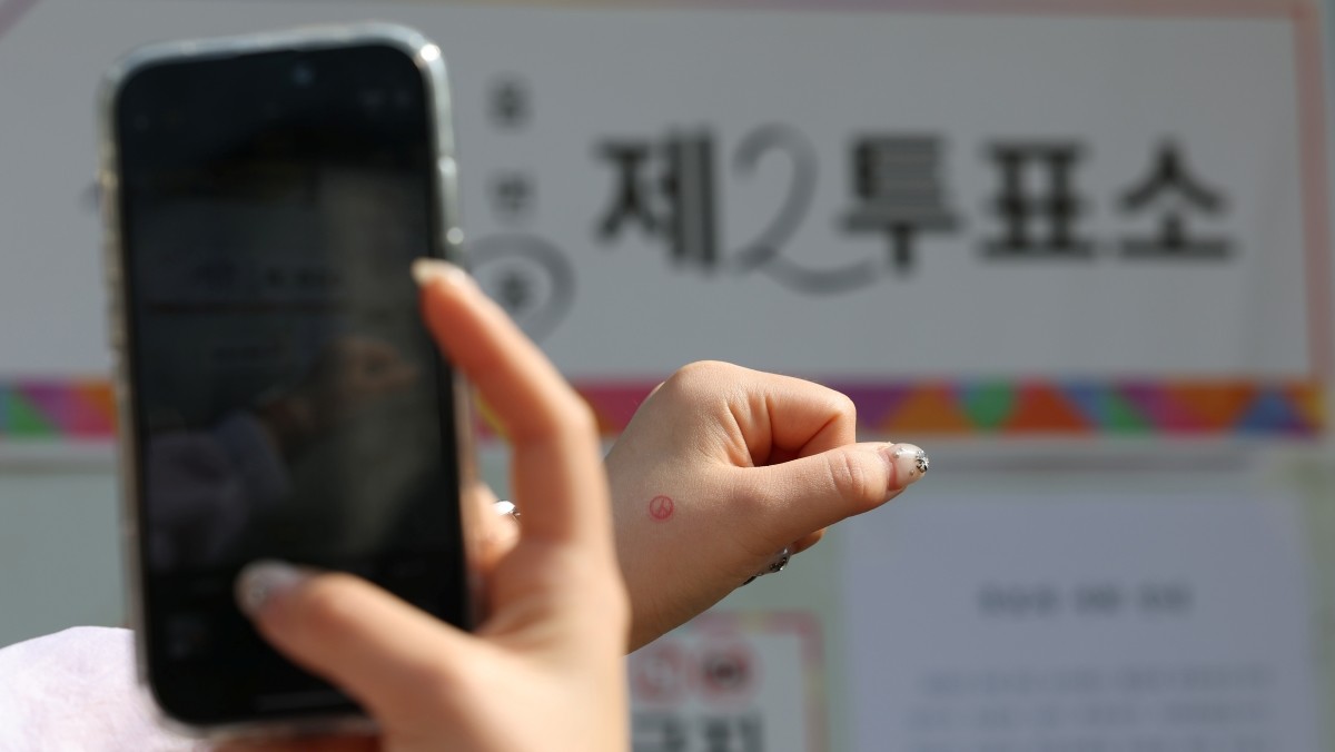 한 유권자가 투표를 마치고 인증샷을 남기고 있다. 기사의 이해를 돕기 위한 사진 / 뉴스1