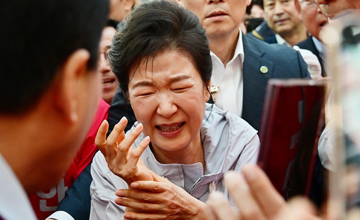 박근혜 전 대통령이 27일 경남 진주시 대안동 진주중앙시장을 찾아 박완수 국민의힘 경남도지사 후보, 한경호 진주시장 후보 지원 유세를 하며 시민과 악수한 뒤 고통스러워 하고 있다.      '선거의 여왕'으로 불린 박 전 대통령은 오랜 기간 여러 유권자를 만나며 악수를 했던 터라 오른손에 붕대를 감고 유세 활동을 펼쳤을 정도로 만성 통증에 시달려 온 것으로 알려졌다.    / 뉴스1