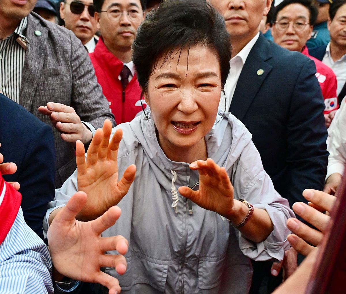 박근혜 전 대통령이 27일 경남 진주시 대안동 진주중앙시장을 찾아 박완수 국민의힘 경남도지사 후보, 한경호 진주시장 후보 지원 유세를 하며 시민과 악수한 뒤 고통스러워 하고 있다. '선거의 여왕'으로 불린 박 전 대통령은 오랜 기간 여러 유권자를 만나며 악수를 했던 터라 오른손에 붕대를 감고 유세 활동을 펼쳤을 정도로 만성 통증에 시달려 온 것으로 알려졌다. / 뉴스1