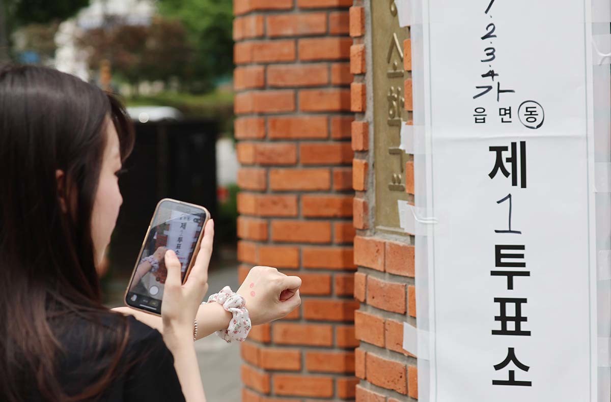 제9회 전국동시지방선거일인 3일 오후 서울 종로구 교동초등학교에 마련된 종로 1,2,3,4가동 제1 투표소에서 투표를 마친 시민이 인증샷을 찍고 있다. 전국 광역단체장 16명, 교육감 16명, 시·군·구 기초단체장 227명, 광역의원 933명, 기초의원 3천35명 등 총 4천227명을 선출하는 이번 선거는 오전 6시부터 오후 6시까지 전국 1만4천288곳의 투표소에서 일제히 실시된다. / 뉴스1