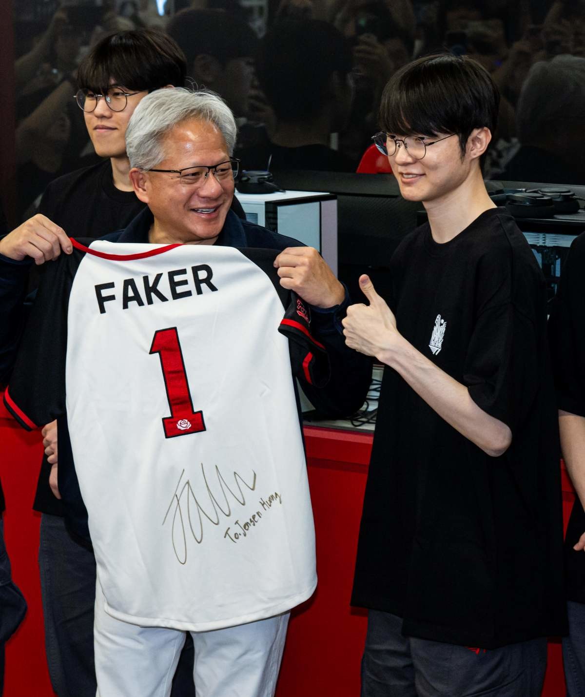 젠슨 황 엔비디아 최고경영자(CEO)가 5일 서울 마포구 ‘T1 베이스 캠프’를 방문해 ‘페이커‘ 이상혁을 비롯한 e스포츠 구단 T1의 리그 오브 레전드(LoL) 선수단에게 선물 받은 ‘페이커’ 사인 유니폼을 들어보이고 있다. / 뉴스1