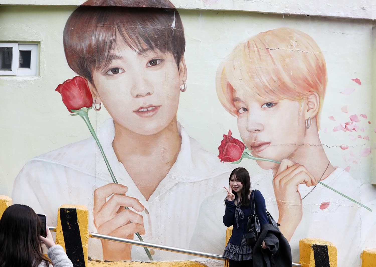 부산 서구 감천문화마을에서 외국인 관광객들이 부산이 고향인 BTS 멤버 정국·지민이 그려진 대형 벽화를 배경으로 기념촬영을 하고 있다. / 2026년 3월 19일자 뉴스1 사진