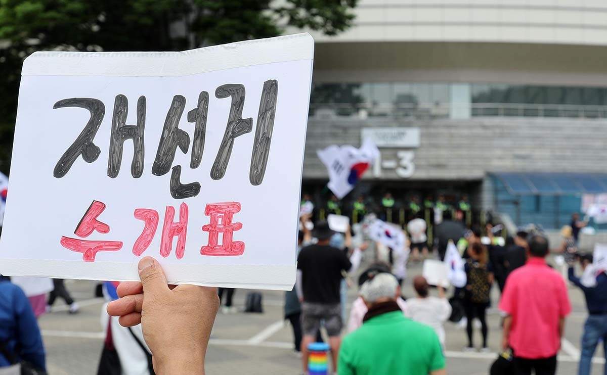 제9회 전국동시지방선거 투표용지 부족 사태에 반발한 시민들이 8일 서울 송파구 올림픽공원 핸드볼경기장 개표소 앞에 모여 재선거를 요구하는 구호를 외치고 있다. / 뉴스1