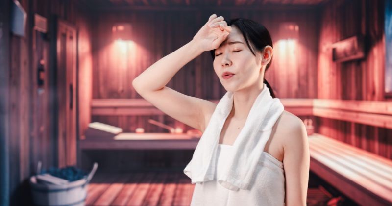 사우나에서 땀을 흘리는 젊은 여성 / 셔터스톡