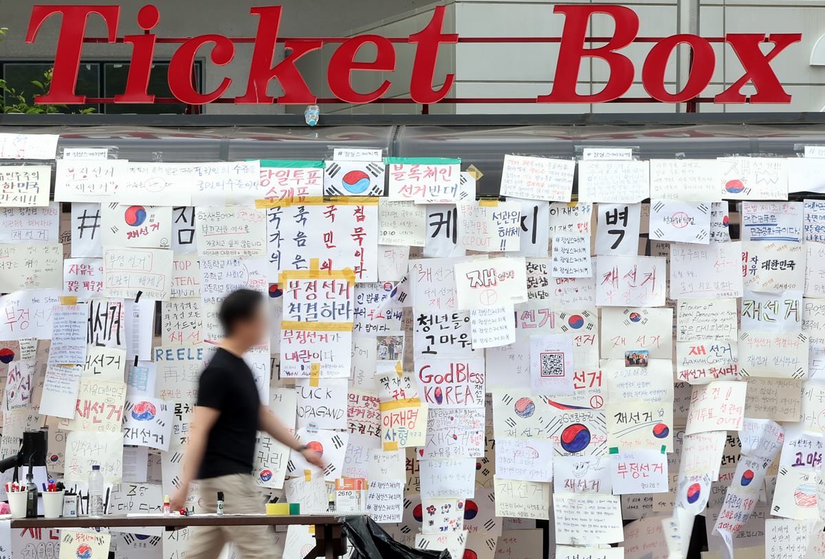 제9회 전국동시지방선거 투표용지 부족 사태를 규탄하며 재선거를 요구하는 집회가 계속되고 있는 8일 서울 송파구 올림픽공원 핸드볼경기장 인근 티켓 부스에 재선거를 요구하는 메시지가 붙어 있다. 자료 사진 / 뉴스1