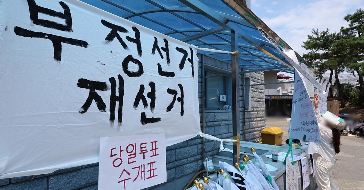 제9회 전국동시지방선거 투표용지 부족 사태에 반발한 시민들이 9일 서울 송파구 올림픽공원 핸드볼경기장에 설치된 개표소 앞에서 재선거를 촉구하며 피켓을 붙이고 있다. / 뉴스1