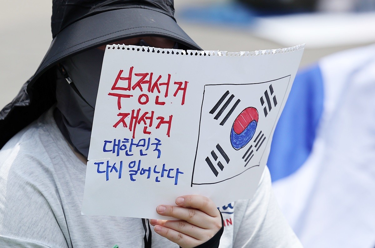 제9회 전국동시지방선거 투표용지 부족 사태에 반발하는 한 시민이 지난 9일 서울 송파구 올림픽공원 핸드볼경기장에 설치된 개표소 앞에서 재선거를 촉구하며 구호를 외치고 있다. 기사 이해를 돕기 위한 자료 사진 / 뉴스1