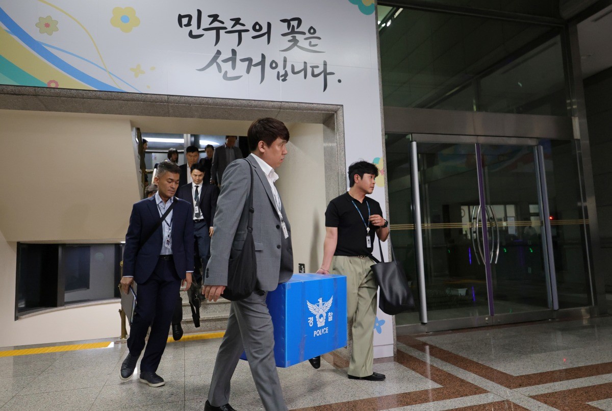 6·3 지방선거 투표용지 부족 사태를 수사하는 검경 합동수사본부 수사관들이 11일 경기 과천시 중앙선거관리위원회에 대한 압수수색을 마친 후 압수품 상자를 들고 이동하고 있다. / 뉴스1