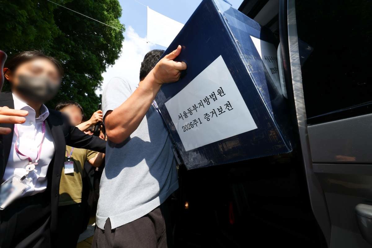 김지연 서울동부지방법원 부장판사와 관계자들이 지난 10일 오후 6·3 지방선거 투표용지 부족 사태가 발생한 잠실7동 제2투표소였던 서울 송파구 우성아파트 노인정의 현장 검증을 마친 뒤 증거물을 들고 차량에 오르고 있다 / 뉴스1
