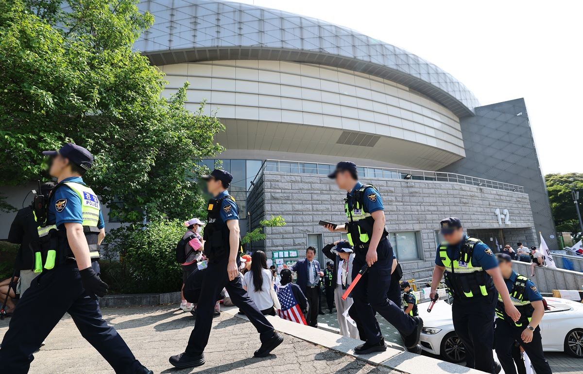 제9회 전국동시지방선거 투표용지 부족 사태를 규탄하는 개표소 봉쇄 시위가 계속된 11일 서울 송파구 올림픽공원 핸드볼경기장 앞에서 경찰이 이동하고 있다. 기사 이해를 돕기 위한 자료 사진 / 뉴스1