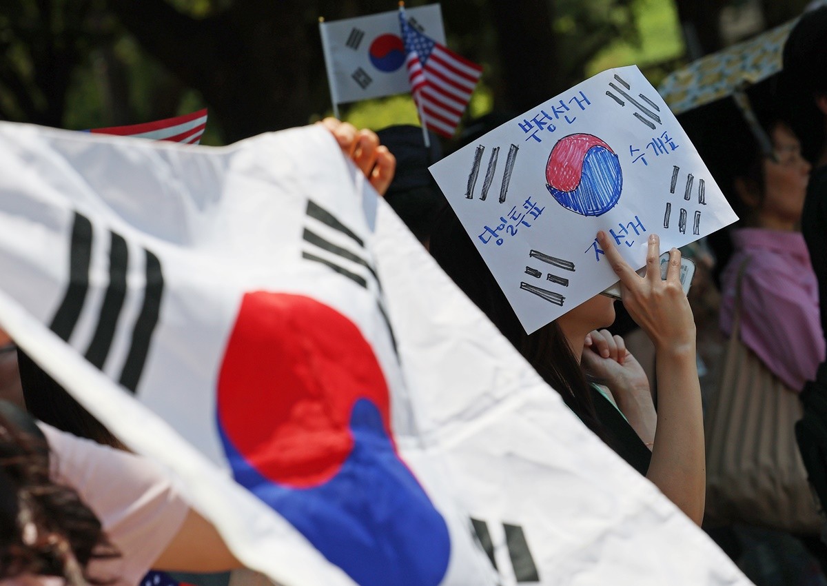 제9회 전국동시지방선거 투표용지 부족 사태를 규탄하는 개표소 봉쇄 시위가 11일째 이어진 지난 15일 서울 송파구 올림픽공원 핸드볼경기장 앞에서 참가자들이 태극기를 흔들며 '부정선거 재선거' 구호를 외치고 있다. 자료 사진 / 뉴스1