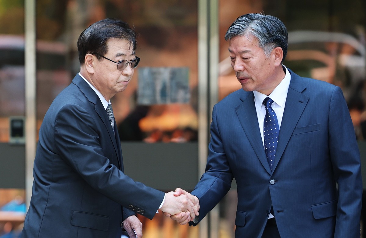 서훈 전 국가안보실장과 김홍희 전 해양경찰청장이 16일 서울 서초구 서울중앙지방법원에서 열린 서해 공무원 피격 사건 관련 허위공문서 작성 및 행사 등 항소심 선고 공판에서 나란히 무죄를 선고받은 후 법정을 나서며 악수를 나누는 모습 / 뉴스1