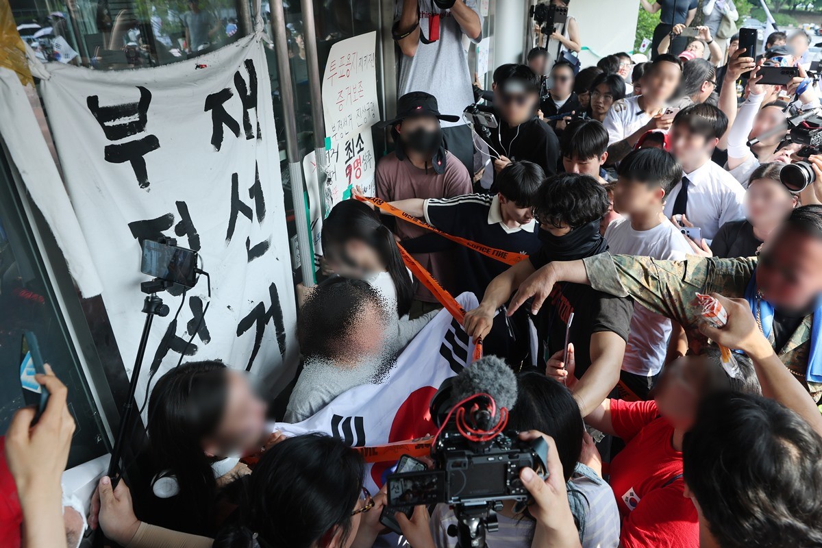 6·3 지방선거 투표용지 부족 사태로 시작한 서울 송파구 올림픽공원 핸드볼경기장 일대 ‘개표소 봉쇄 시위’가 이어지는 16일 한 시민이 대한체육회 관계자들의 핸드볼경기장 진입을 막고있는 모습 / 뉴스1