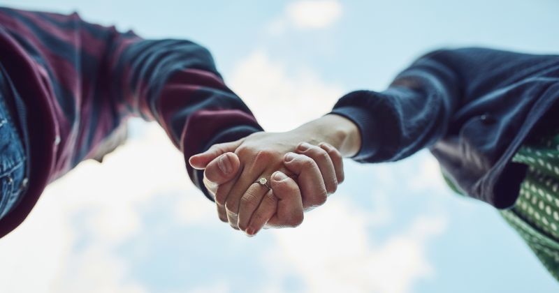 낮은 각도, 야외 및 커플은 함께 푸른 하늘과 신뢰, 사랑과 로맨스로 손을 잡고, 모험 및 유대감 / 셔터스톡