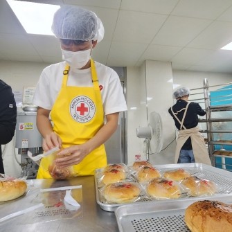 독립운동 김영석 독가의 고손인 대구대곡고등학교 2학년 김경민 군이 사랑의 빵 나눔 행사에서 빵을 담고 있다. / 광복회 제공