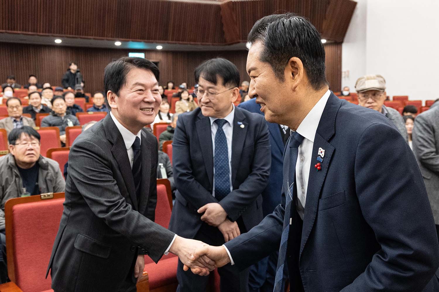 정청래 더불어민주당 대표가 2025년 12월 9일 서울 여의도 국회 도서관 강당에서 열린 '2025 대한민국 한센인대회'에 참석해 안철수 국민의힘 의원과 악수하고 있다. / 뉴스1
