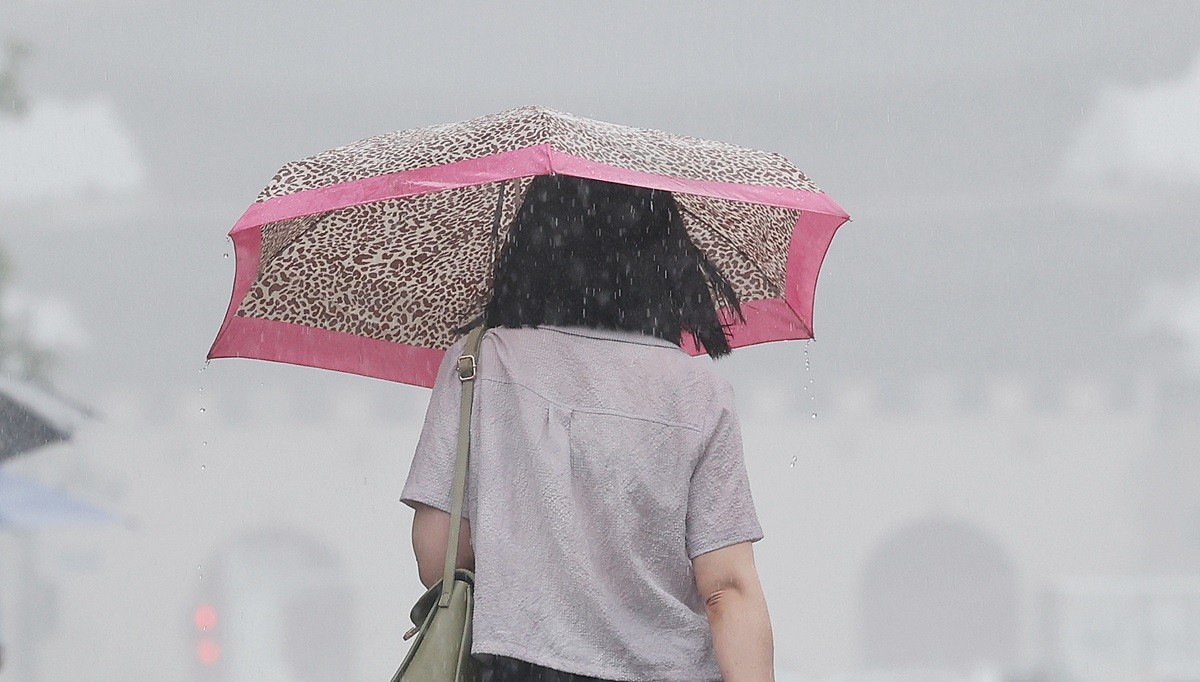 장맛비가 내리는 서울 도심에서 한 시민이 우산을 쓰고 걸어가고 있다. 기사 이해를 돕기 위한 자료 사진. 올해 장마 시작은 제주도는 6월 30일, 내륙 지역은 7월 초에 시작될 가능성이 있다고 24일 뉴스1이 전했다. 매체는 2026년 장마 시작 전망과 관련해 '현재 예보대로라면 제주는 6월 30일~7월 1일 비를 계기로 장마에 들어설 가능성이 있다'라며 '전국적인 장마 확대 여부는 7월 3일 전후 기압계 변화가 분수령이 될 전망'이라고 전했다. / 뉴스1