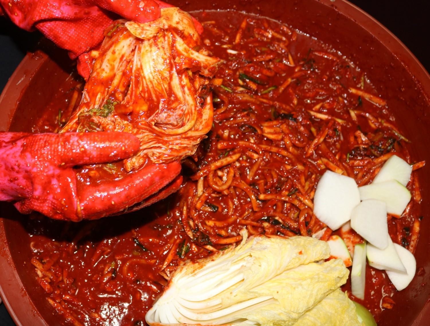 배추에 양념을 버무리며 김치를 담그는 과정. / 셔터스톡