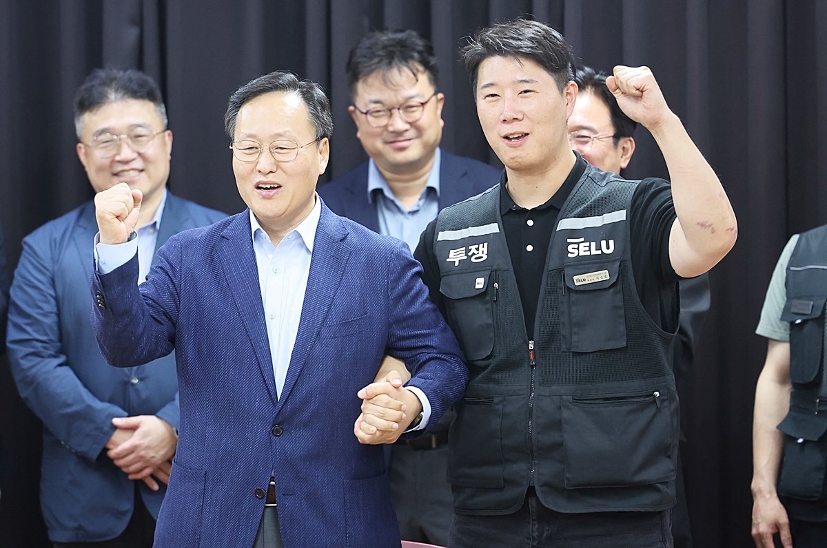 지난달 20일 경기도 수원시 장안구 경기고용노동청에서 열린 삼성전자 임금협상을 마친 후 여명구 삼성전자 DS 피플팀장과 최승호 삼성그룹 초기업노동조합 삼성전자지부 위원장이 잠정 합의한에 서명한 뒤 파이팅을 외치고 있다. 기사 이해를 돕기 위한 자료 사진 / 뉴스1