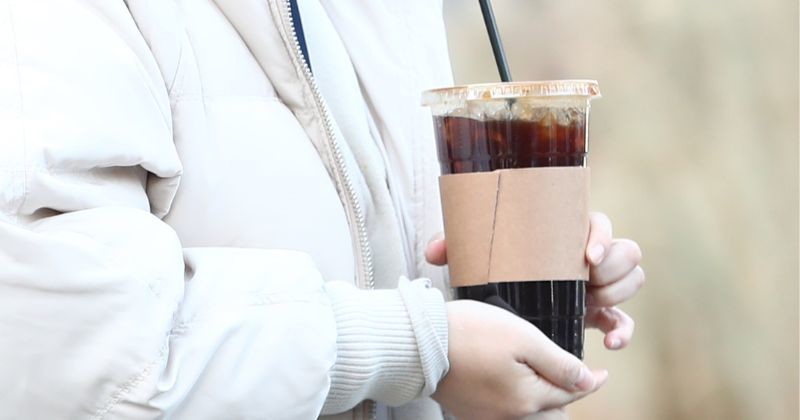광화문네거리에서 시민이 커피를 들고 발걸음을 옮기고 있다 / 뉴스 1