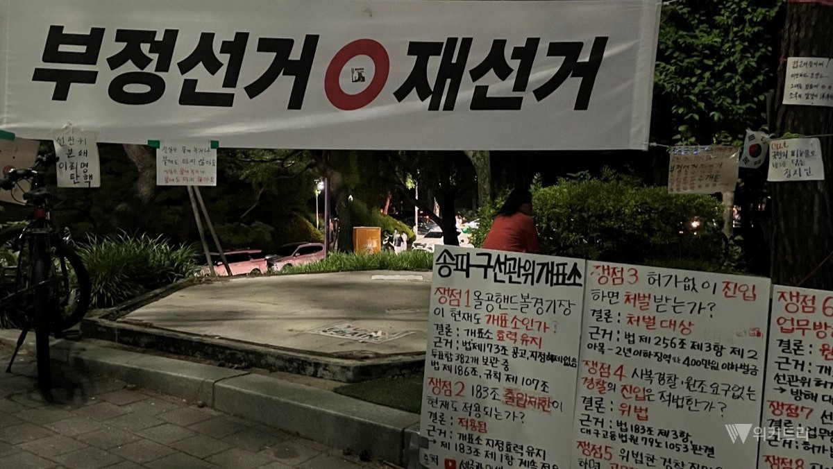올림픽공원 집회 현장에 ‘부정선거’와 ‘재선거’ 문구가 적힌 현수막과 대자보가 걸려 있다. / 위키트리