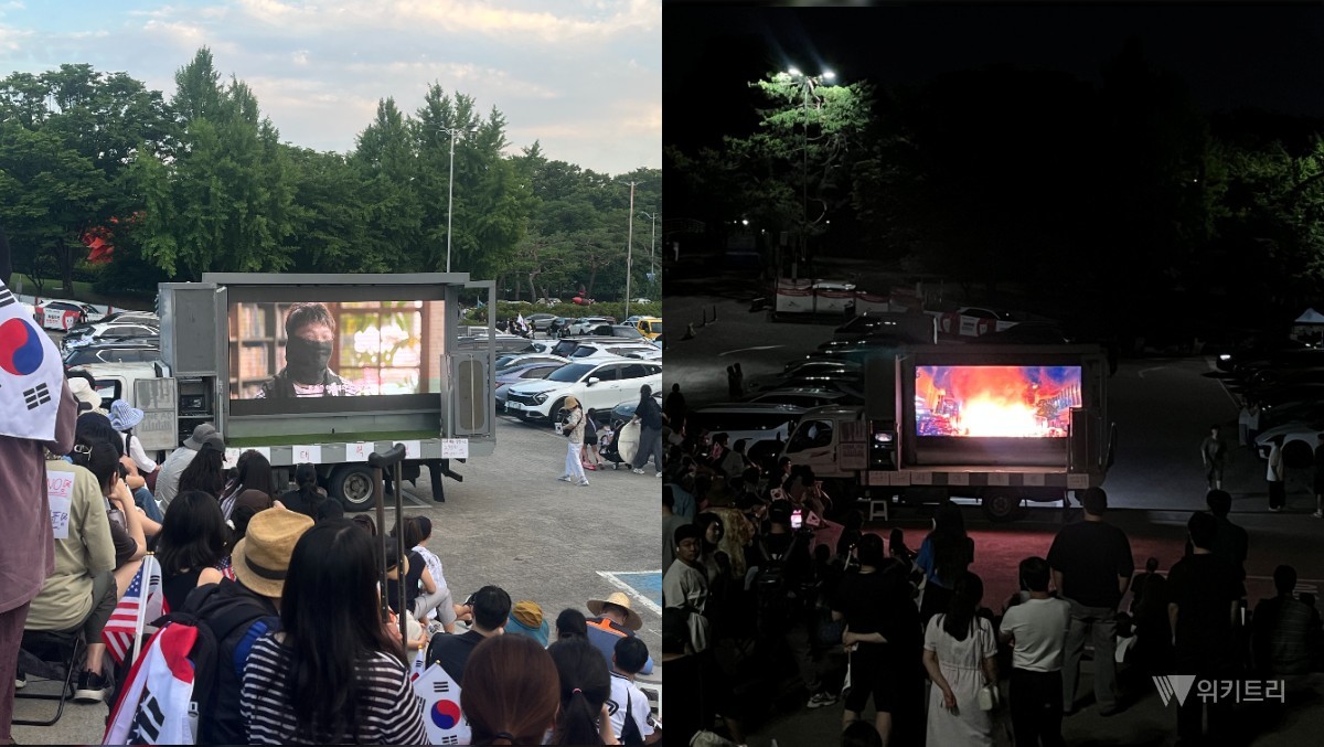 올림픽공원 집회 현장에 세워진 차량에서 부정선거 의혹을 다룬 다큐멘터리가 상영되고 있다. 시민들이 차량 앞에 모여 영상을 지켜보고 있다. / 위키트리