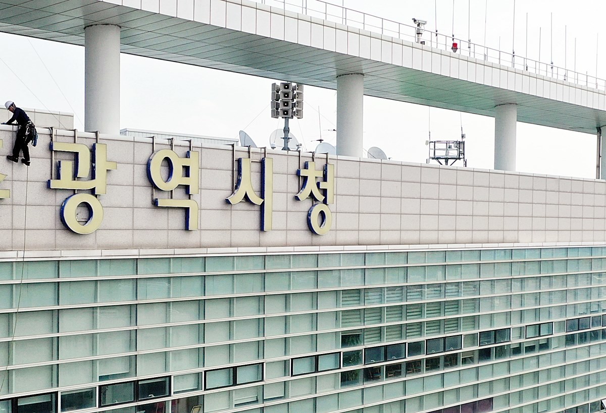 30일 광주시 서구 치평동 광주광역시청 외벽에서 작업자들이 '광주광역시'라고 적힌 조형물을 철거하고 있다. 이 간판은 7월 1일 출범하는 전남광주통합특별시 문구가 적힌 간판으로 대체될 예정이다. / 연합뉴스