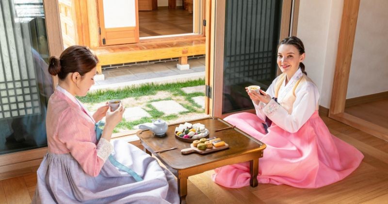 화창한 오후에 아늑한 한국 가정집에서 친구들과 전통 차와 스낵을 즐겨 보십시오 / 셔터스톡