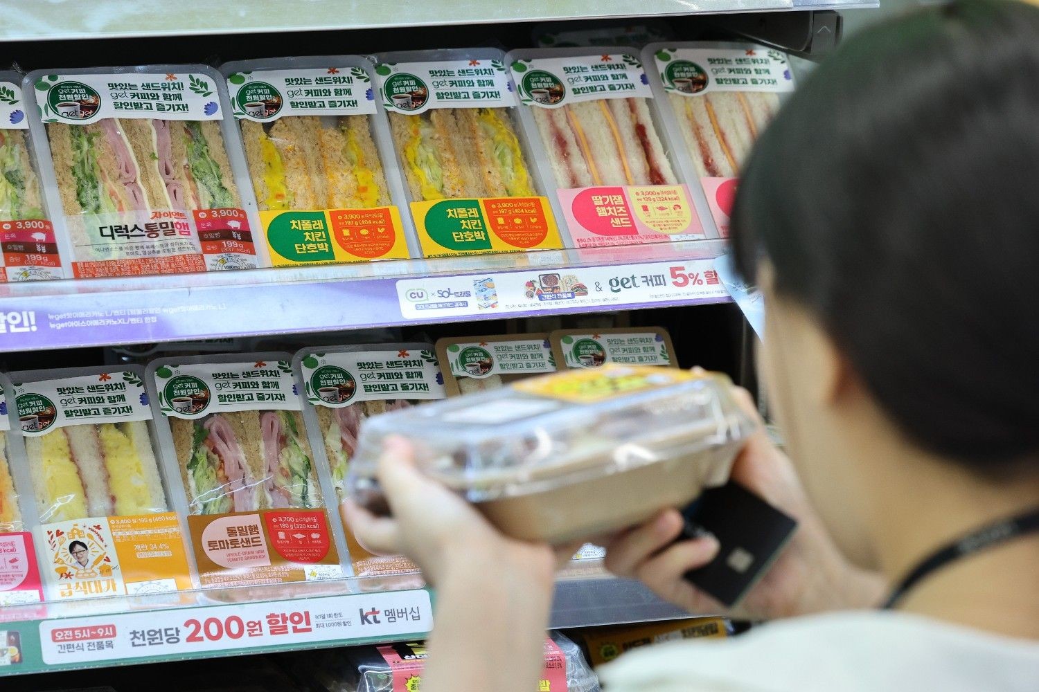 편의점에서 행사 상품을 살펴보는 소비자의 모습. / 셔터스톡