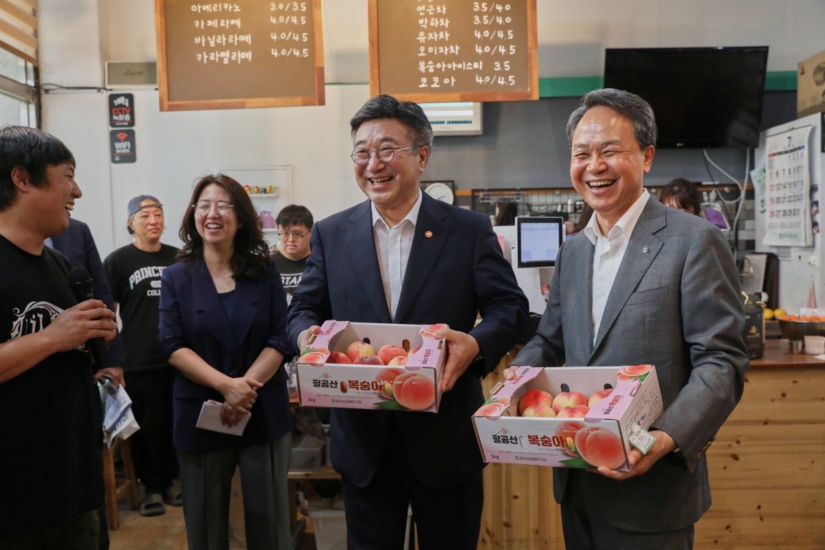 이날 안심마을 협동조합에서 (사진 오른쪽에서 두번째)윤호중 행정안전부 장관, (사진 오른쪽에서 첫번째)진옥동 신한금융그룹 회장이 과일을 구매하고 있다. / 신한금융 제공
