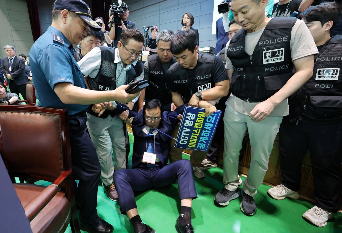15일 오후 충북 충주시장 당선무효 소청과 관련한 재검표가 진행되는 국립한국교통대학교 다목적 강당에서 더불어민주당 맹정섭 후보가 강제 퇴거 조치 당하고 있다. / 연합뉴스