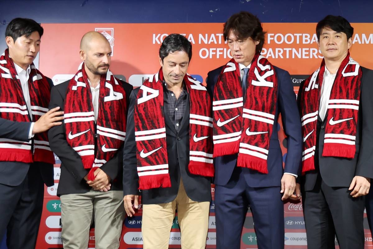 당시 홍명보 대한민국 축구 국가대표팀 감독이 2024년 8월 26일 오전 서울 종로구 축구회관에서 열린 '2026 북중미 월드컵 아시아지역 3차 예선 대표팀 소집 명단 발표 기자회견'이 끝난 뒤 기념촬영에 앞서 티아고 마이아 분석 코치와 주앙 아로소 수석 코치에게 자리를 권하고 있다. / 뉴스1