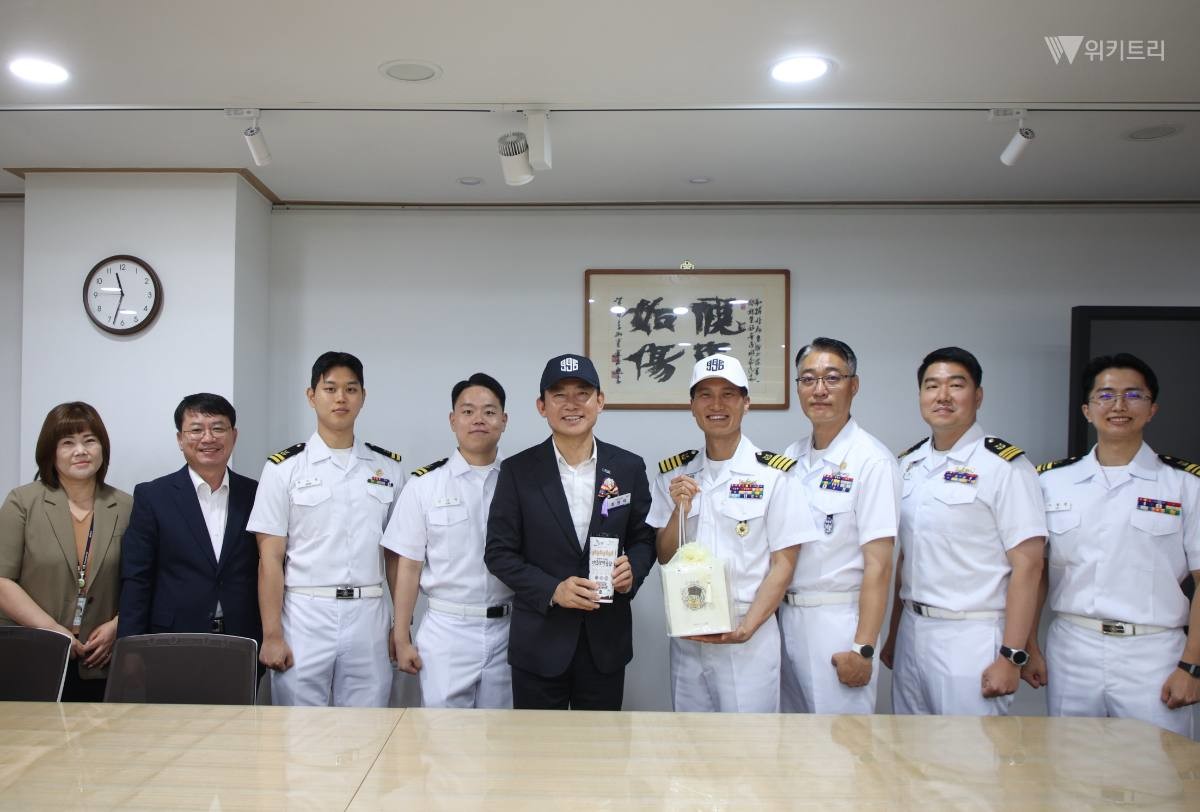 최현덕 남양주시장이 해군 관계자와 기념품을 교환하고 참석자들과 기념촬영을 하고 있다