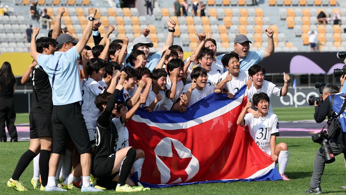 지난 5월 북한 내고향여자축구단과 도쿄 베르디의 경기에서 우승을 거둔 내고향 선수들이 인공기를 펼쳐 기념 촬영을 하고 있다. / 뉴스1