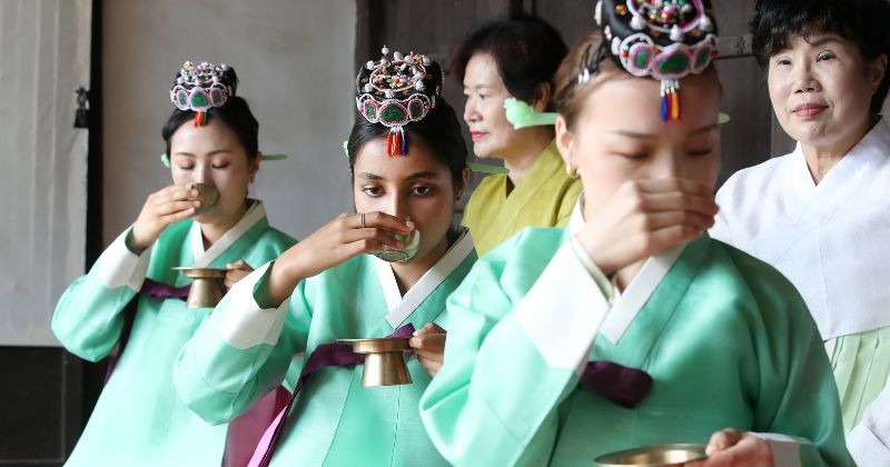 한복을 입은 외국인들이 전통 예절 체험 프로그램에서 술잔을 드는 예법을 배우고 있다. / 뉴스1