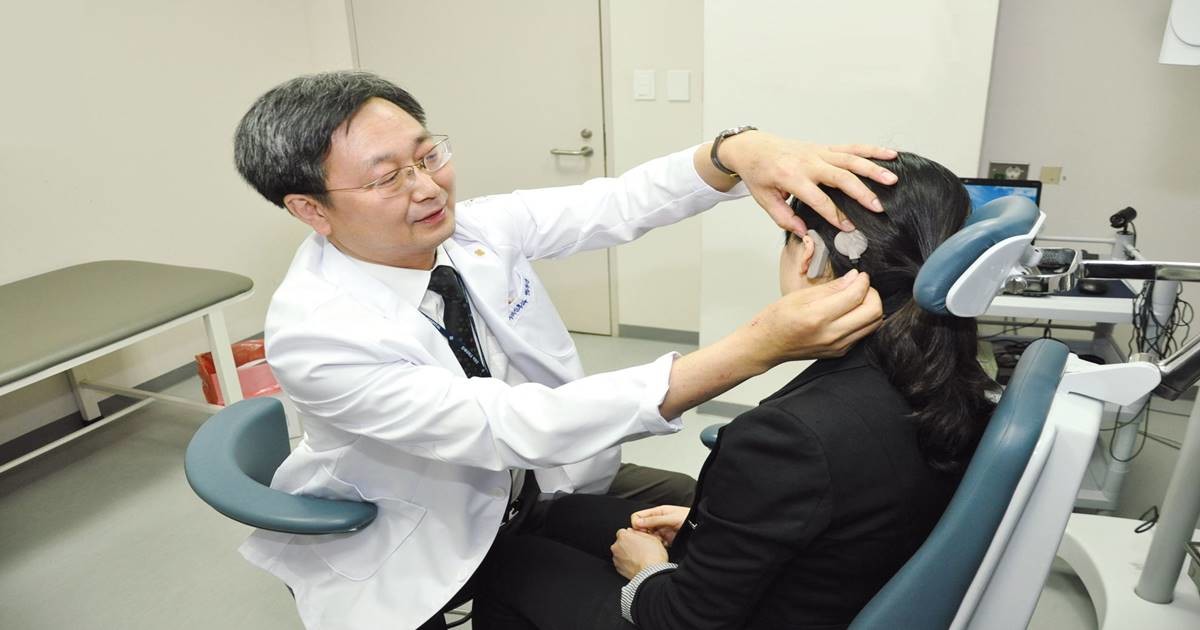 해운대백병원 백무진 교수가 난청 환자의 인공와우 외부장치 상태를 확인하며 상담을 진행하고 있다. / 사진제공=백병원
