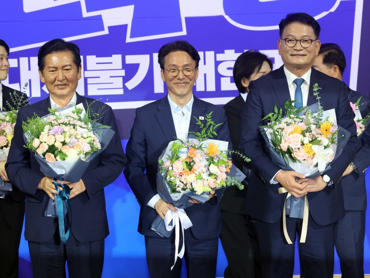 더불어민주당 본경선 후보로 진출한 정청래(왼쪽부터), 김민석, 송영길 후보가 지난 23일 오후 서울 여의도 국회 의원회관에서 열린 당대표·최고위원 선출을 위한 예비경선 결과발표 뒤 단상에 올라 기념촬영을 하고 있다. / 뉴스1