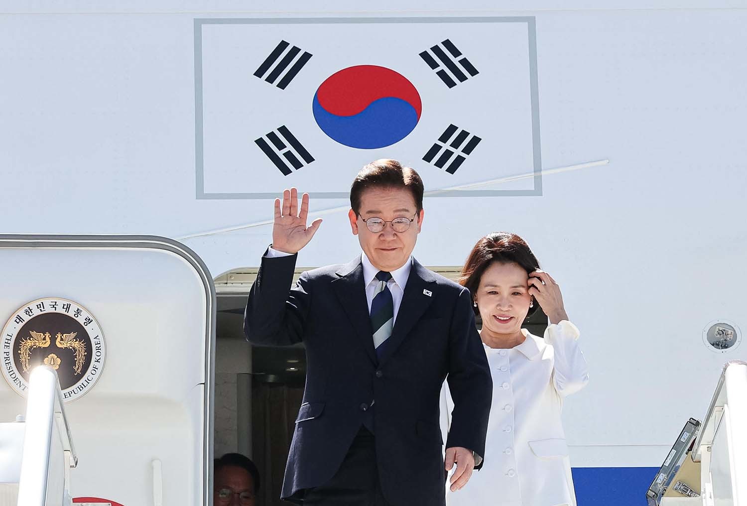 브라질을 국빈 방문한 이재명 대통령과 김혜경 여사가 26일(현지시간) 브라질리아 공군기지에 도착해 환영객들에게 인사를 하고 있다. / 뉴스1