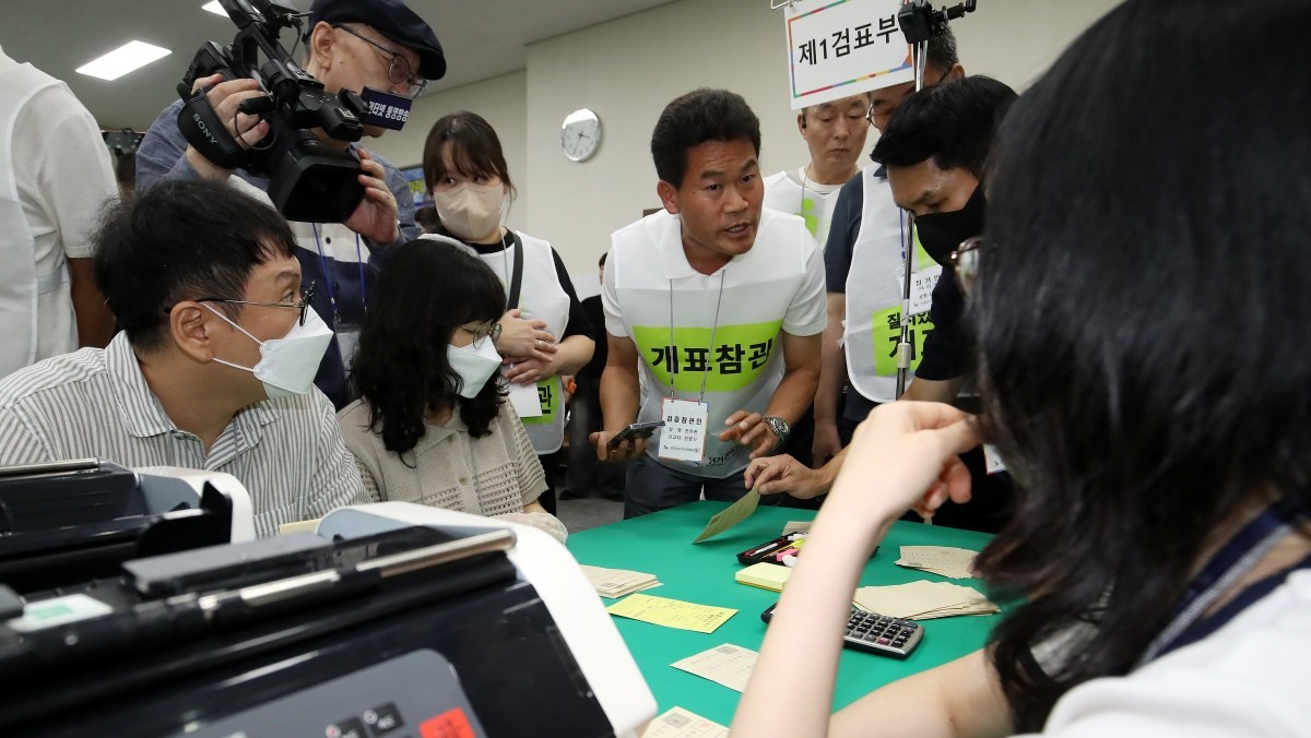 27일 경남 창원 성산구 경남도선거관리위원회 대회의실에서 도 선관위 관계자들이 6·3 지방선거에서 44표 차로 당락이 갈린 통영시장 선거 재검표를 진행하고 있다. 뒤로는 한국사 강사 출신의 유튜버 전한길 씨가 개표참관인으로 참석해 이의를 제기하고 있다 / 뉴스1