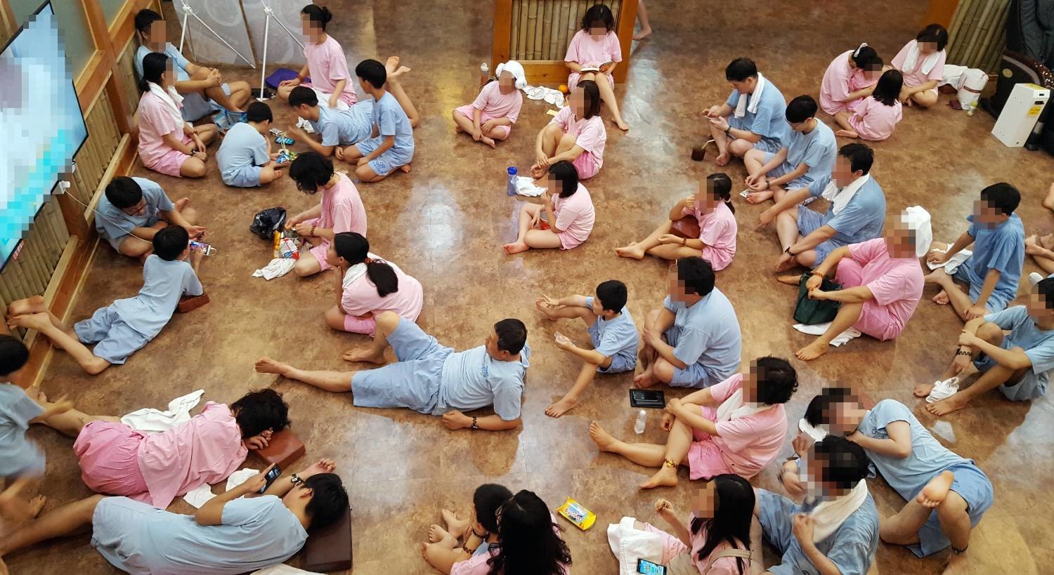 찜질복을 입고 휴게 공간에서 쉬고 있는 찜질방 이용객들. / 뉴스1