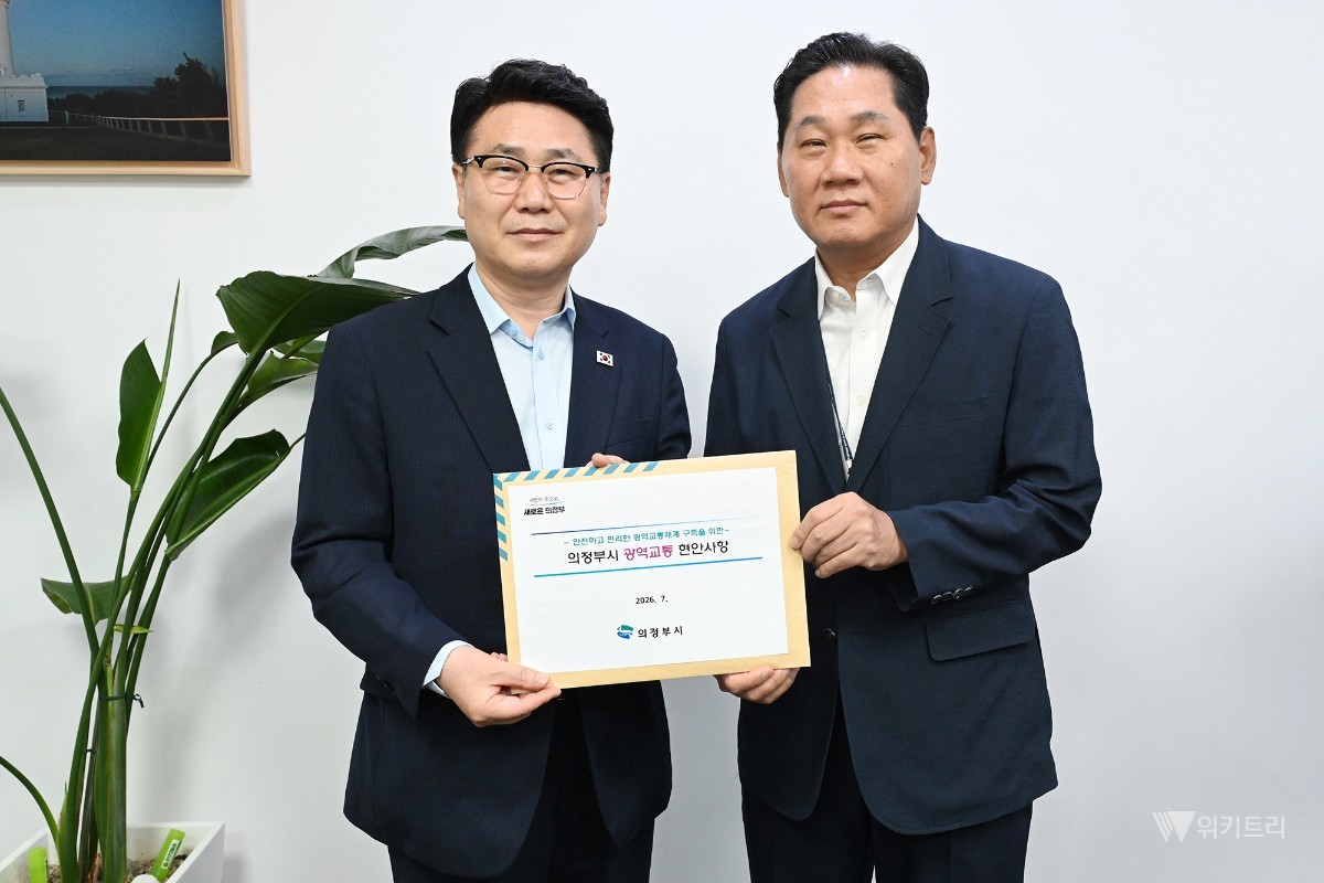 김원기 의정부시장이 7월 30일 국회에서 김용석 대도시권광역교통위원장에게 ‘8호선 의정부 연장’ 반영 촉구 시민 서명부와 광역교통 현안사항이 담긴 자료를 전달한 뒤 기념촬영을 하고 있다