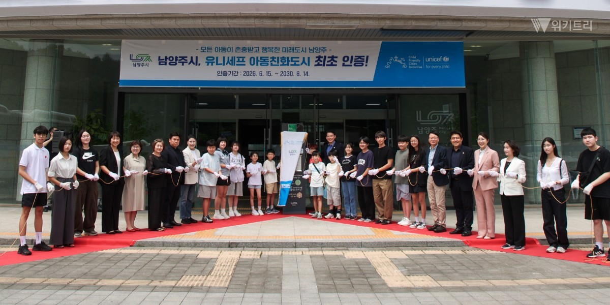 최현덕 시장이 유니세프 아동친화도시 인증 현판을 제막한 뒤 기념촬영을 하고있다