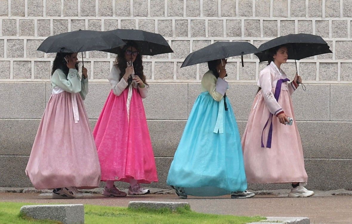 외국인 관광객들이 한복을 입은 채 우산을 쓰고 경복궁 일대를 둘러보고 있다. / 뉴스1