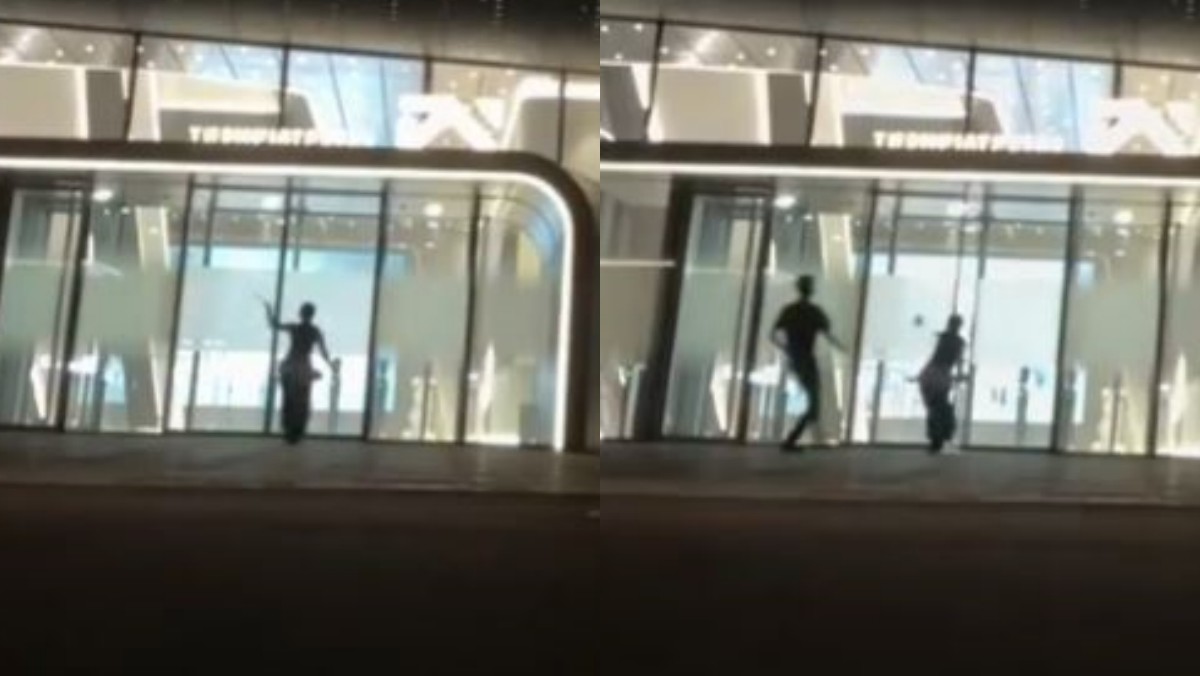YG 사옥 출입문을 골프채로 여러 차례 내려치는 20대 여성의 모습. / 엑스(X) 캡처