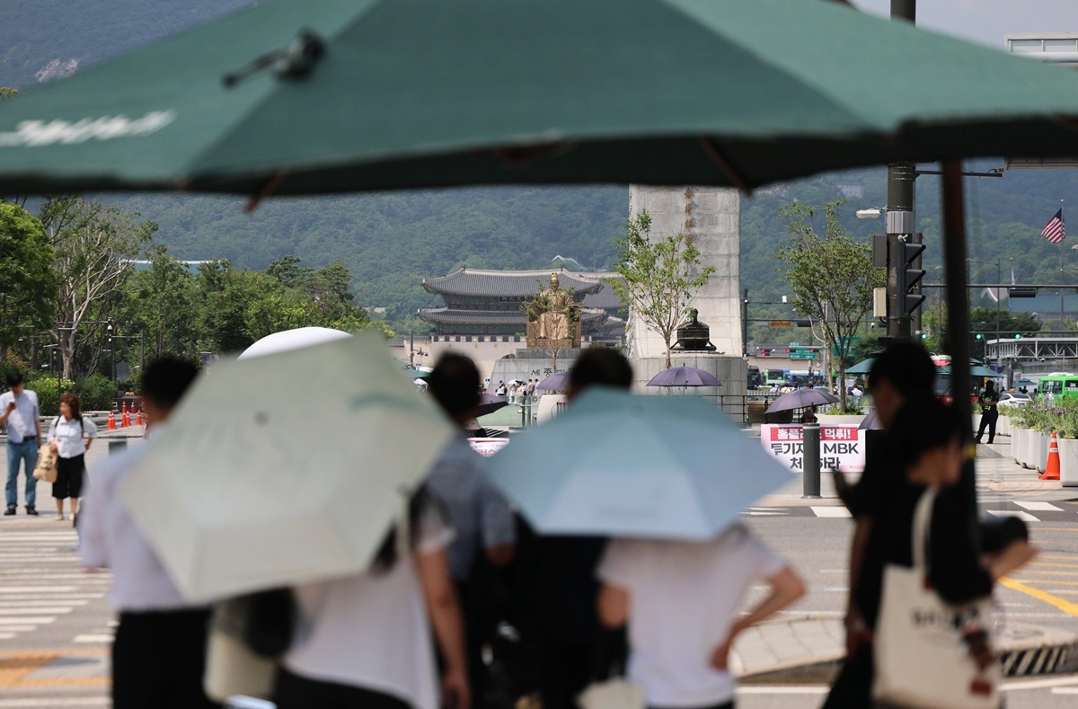 폭염 속 서울 종로구 광화문 네거리에서 시민들이 횡단보도 그늘막 아래에 모여 햇볕을 피하고 있다. 기사 이해를 돕기 위한 자료 사진. 거리에서 시민들이 잠시 더위를 피할 수 있는 폭염 저감 시설인 '그늘막'도 크게 늘어난 것으로 집계됐다. 행정안전부에 따르면 전국에 있는 보도, 횡단보도 앞 등에 설치된 그늘막은 올해 기준 3만 9514개인 것으로 집계됐다. 일반적인 '접이식 그늘막'은 3만 351개, 물안개 분사 장치(쿨링포그)나 의자 겸용 등 기술이 적용된 '스마트 그늘막'은 9163개다.      / 뉴스1