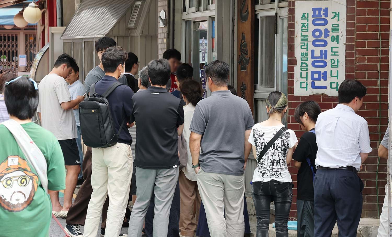 서울 마포구에 한 평양냉면집 앞에 시원한 냉면을 찾는 손님들이 길게 줄지어 기다리고 있다. / 뉴스1