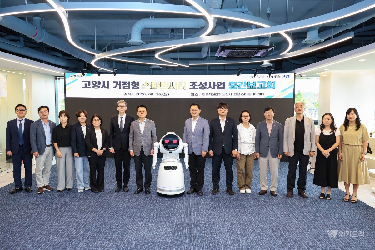 민경선 고양특례시장과 AI 로봇 사회자 ‘고양ON’을 비롯한 중간보고회 참석자들이 기념촬영을 하고 있다