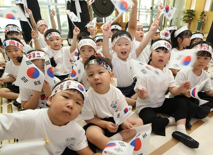 81주년 광복절을 하루 앞둔 14일 대구 달성군청에서 '빛을 잇다'를 주제로 열린 광복절 기념행사에 참가한 달성군 화원권역 10개 국공립 어린이집 교사와 어린이들이 태극기를 흔들고 있다. 2026.8.14/뉴스1